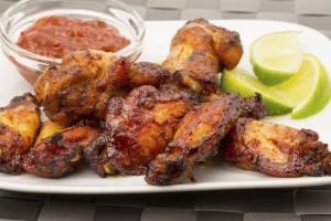 Chicken wings with a tomato dip and lime garnish - studio shot